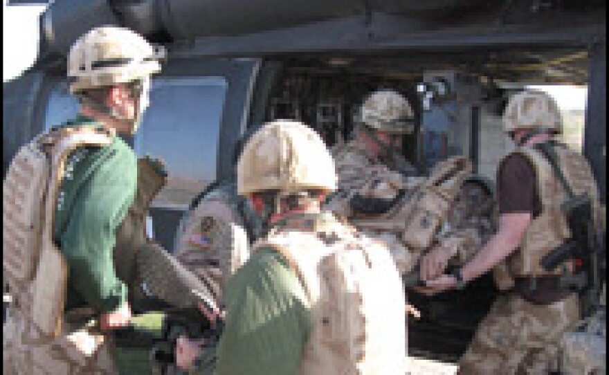 Members of the Arkansas National Guard medevac unit load an injured soldier into a Blackhawk helicopter near the Iranian border.