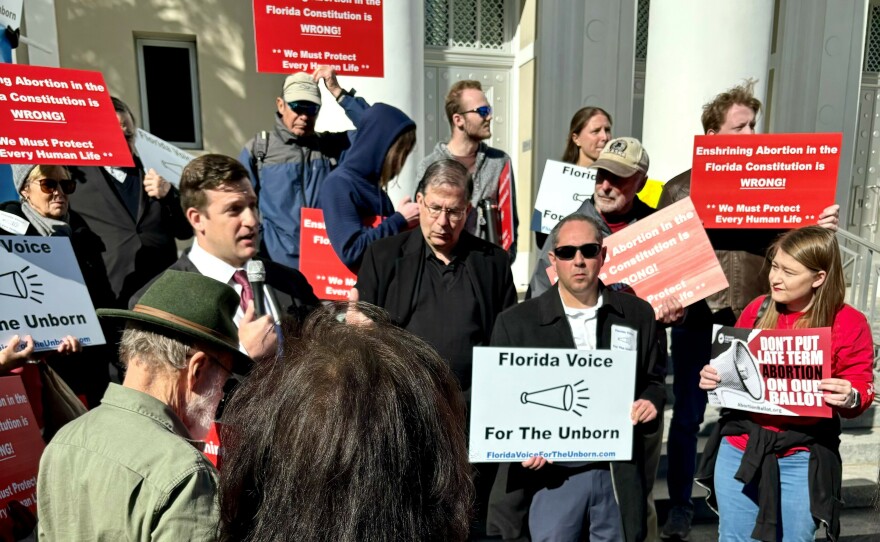 Andrew Shirvell (center in sunglasses) is founder of the anti-abortion group Florida Voice for the Unborn. He's standing on the steps of the Florida Supreme Court protesting abortion access. He said if Florida passes a bill letting parents collect damages for the loss of a pregnancy it would give abortion opponents another law to point to in the effort to establish fetal personhood in the state.