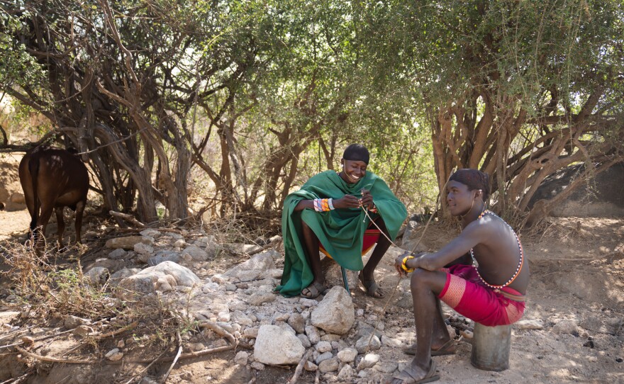 Paris's half-brother Ltesekwa stops to chat with a moran at a campsite near his own. During the dry season small groups of the boys spend months roaming into the mountains in search of pasture and water for their community's cattle.