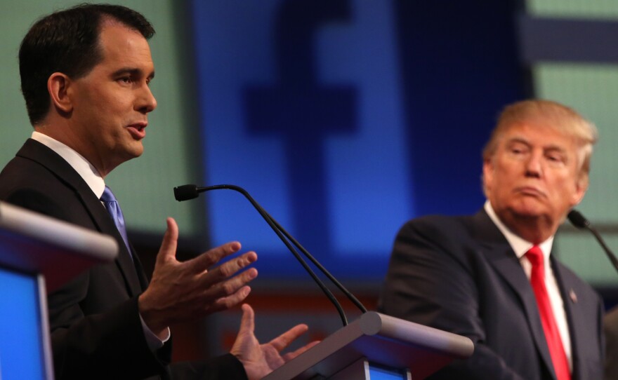 Republican presidential candidate Scott Walker speaks as Donald Trump, listens during the first Republican presidential debate in Cleveland last August.