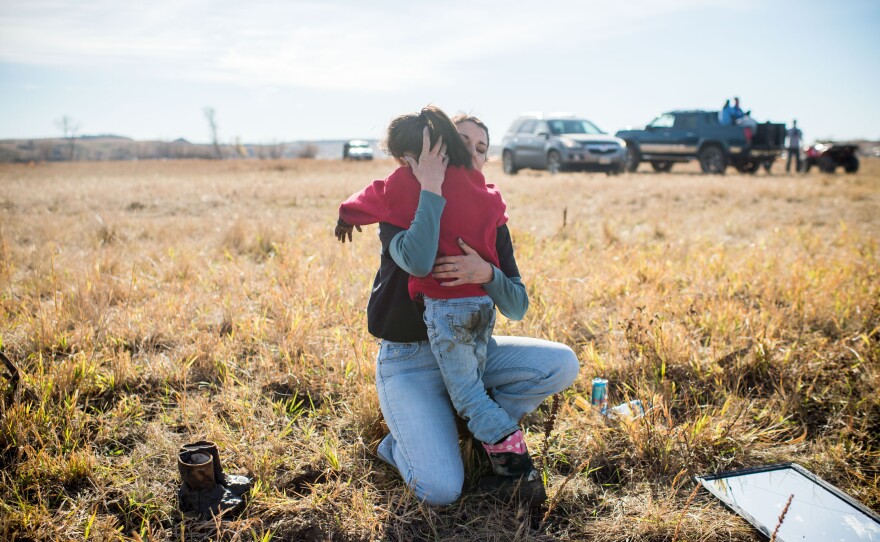 Samantha Putchit Echumblee, 5, of Greenville, Tenn., hugs her mother, Audrie Ellen, during protests at the river.