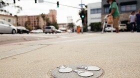 This undated photograph is of one of the more that 100 round stone carvings embedded in the sidewalk along University Avenue in Hillcrest by San Diego artist Doron Rosenthal. 