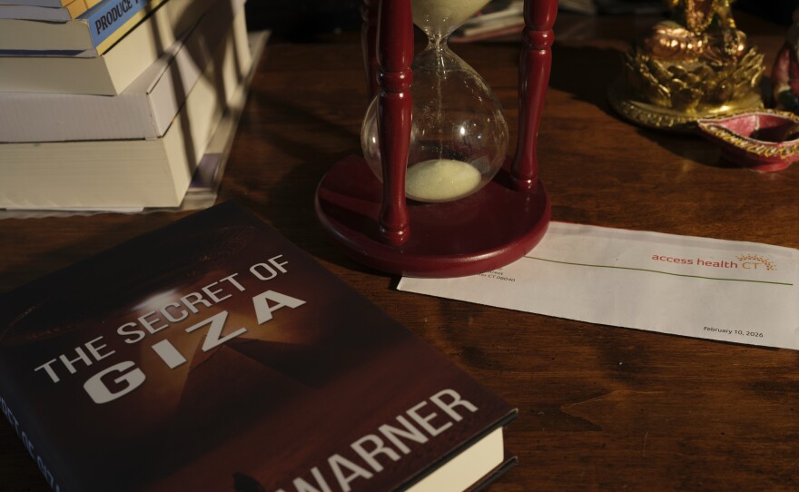 Ken Warner's novel, The Secret of Giza, is the first in a 10-volume series about twins who "are thrust into a war that spans worlds," according to the book description. There's an Access Health CT letter on the desk, too.