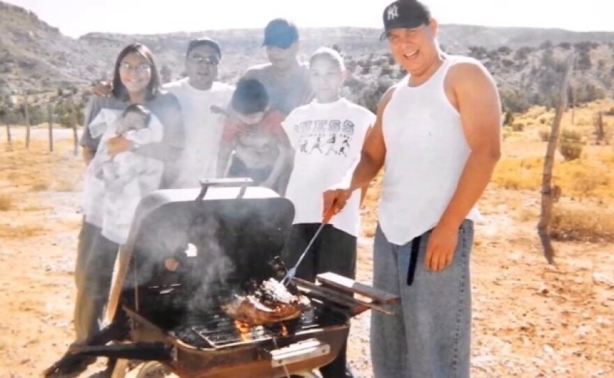 Carlos Yazzie (right) grills with his family. After he was arrested, he was left unmonitored for six hours and died of acute alcohol poisoning.