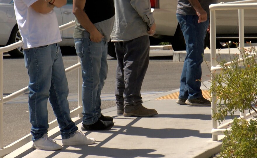 People wait outside the Bank of America ATM in El Centro, CA.
