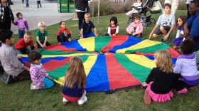 Children circle around the colorful parachute at the City of El Cajon's birthday event.