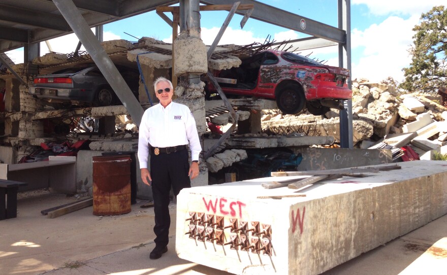 David Martin, director of rescue training at "Disaster City," stands in front of a mock-up of a government building that's been hit by a bomb.