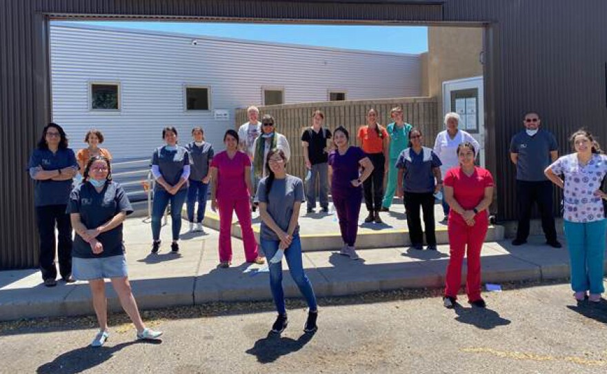 Casa de Salud clinicians, staff and health apprentices socially distance outside their New Mexico clinic. The facility is one of many social safety net clinics that haven't yet received pandemic-related funding and are now on the brink financially.