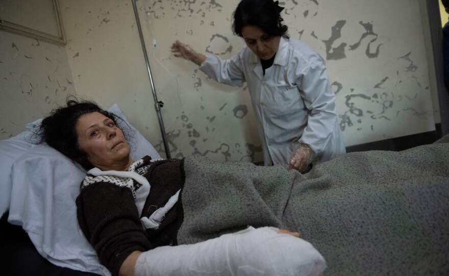 An injured woman lies in a bed at a hospital in the town of Jableh in Syria's northwestern province of Latakia on Tuesday following a deadly earthquake in the area.