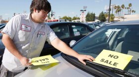 Employee Raul Quecada places a "No Sale" sign on a used Toyota vehicle at a Toyota dealership in Alhambra, Calif., on Jan. 27, one day after Toyota Motor Corp. announced it would halt sales of some of its top-selling models to fix gas pedals that could stick and cause unintended acceleration.