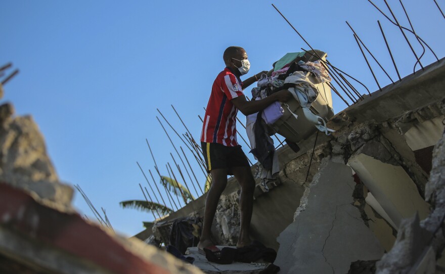 <strong>Sat., Aug. 14:</strong> A man recovers belongings from his home that was destroyed by the earthquake in Les Cayes, Haiti.