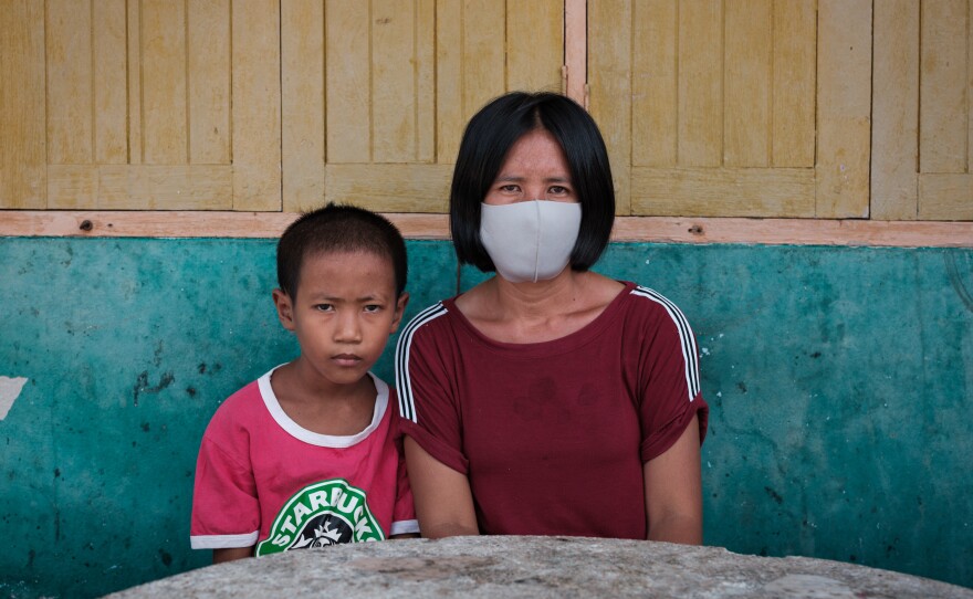 Pranee Thermuangpak, 38, with one of her three children. Pranee's husband, Samart Thermuangpak, a construction worker, tried to kill himself after his application for the 5,000 baht in government aid was denied. Pranee is epileptic and unable to work; her mother needs regular medication.