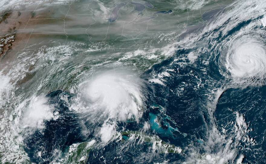 Sally is edging closer to the U.S. Gulf Coast, while Hurricane Paulette moves away from Bermuda out in the Atlantic Ocean. This satellite view also shows smoke from massive wildfires in the U.S. West.