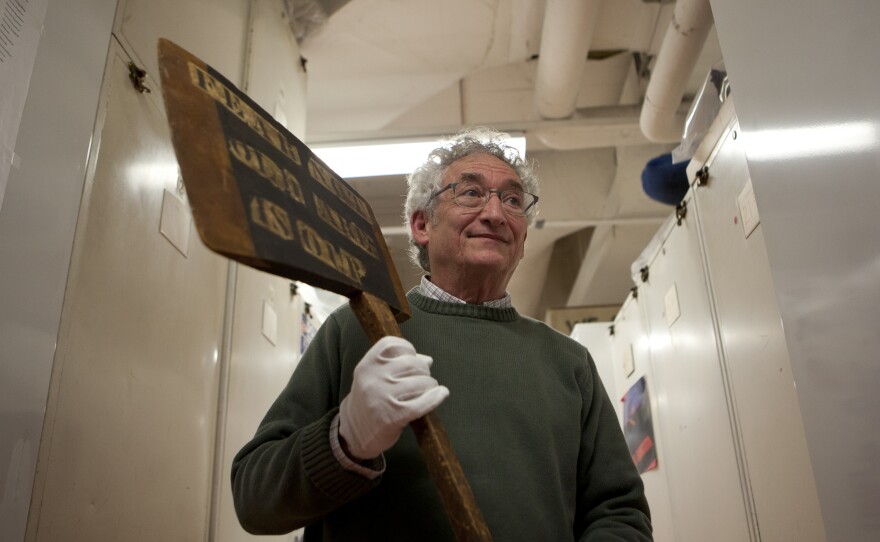 Harry Rubenstein pulls out a large wooden axe that was a campaign prop for Abraham Lincoln at the National Museum of American History in Washington, D.C.
