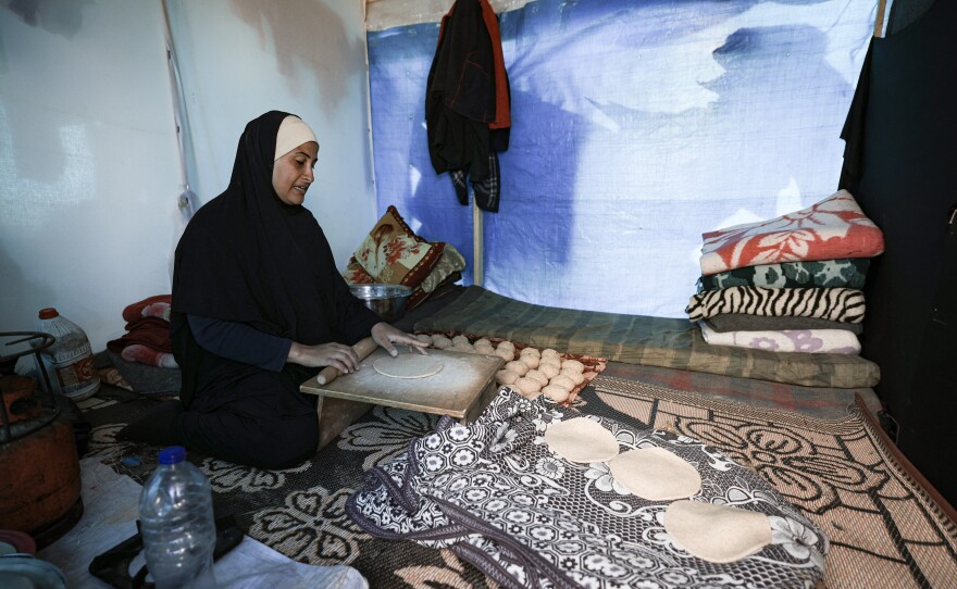 A displaced Palestinian woman prepares bread inside a tent at a makeshift camp in Rafah near the Gaza-Egypt border earlier this month.