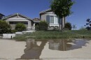 Water flows down a sidewalk from water sprinklers running at a home Thursday, April 2, 2015, in Rancho Cordova, Calif.