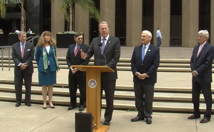 San Diego Mayor Kevin Faulconer is joined by City Attorney Jan Goldsmith (left), County Supervisor Ron Roberts (right) and members of the city-county negotiating team to provide an update on stadium negotiations with the Chargers, June 16, 2015.
