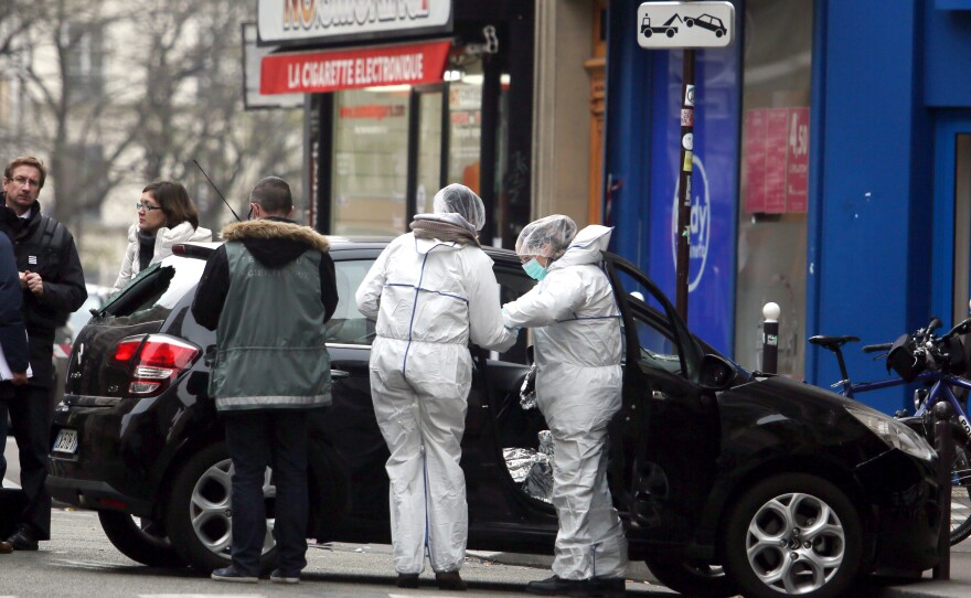 Forensic experts examine a car believed to have been used as an escape vehicle by the assailants. Four of the magazine's founding cartoonists were killed in the attack, according to French news outlets. Eleven other people were injured, four of whom are in critical condition.
