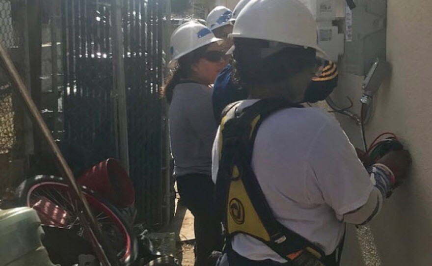 Trainees learn about solar panel wiring during a job training session at a home in Lincoln Park, Dec. 12th, 2018.
