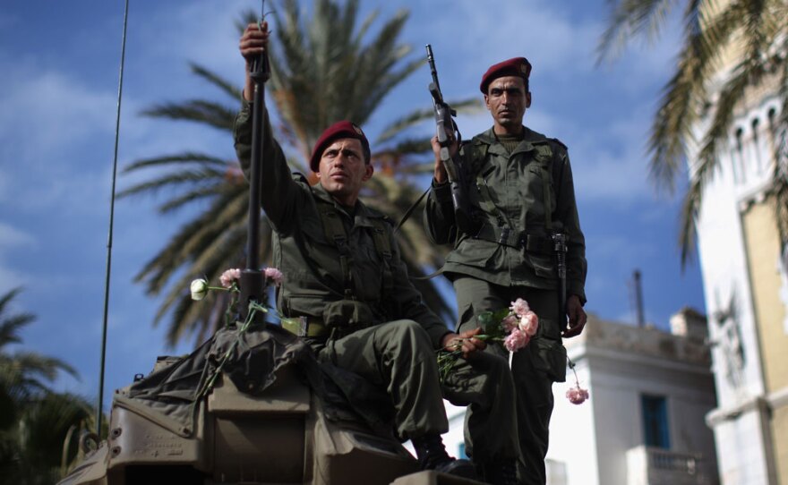 A Tunisian soldier arranges flowers on his tank on Jan. 21 in Tunis.